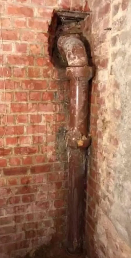 Ancienne colonne d'évacuation en fonte, abîmée et cassée, avant remplacement par Plomberie-Toiture MERTENS B.