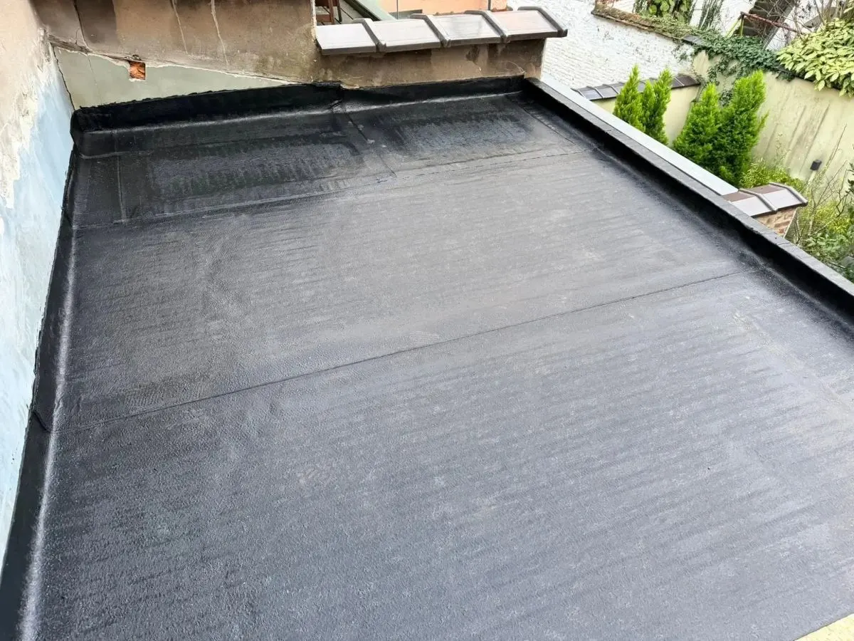 Toiture plate recouverte d'une nouvelle étanchéité bitumineuse soudée, avec relevés le long des murs, par Plomberie-Toiture MERTENS B.
